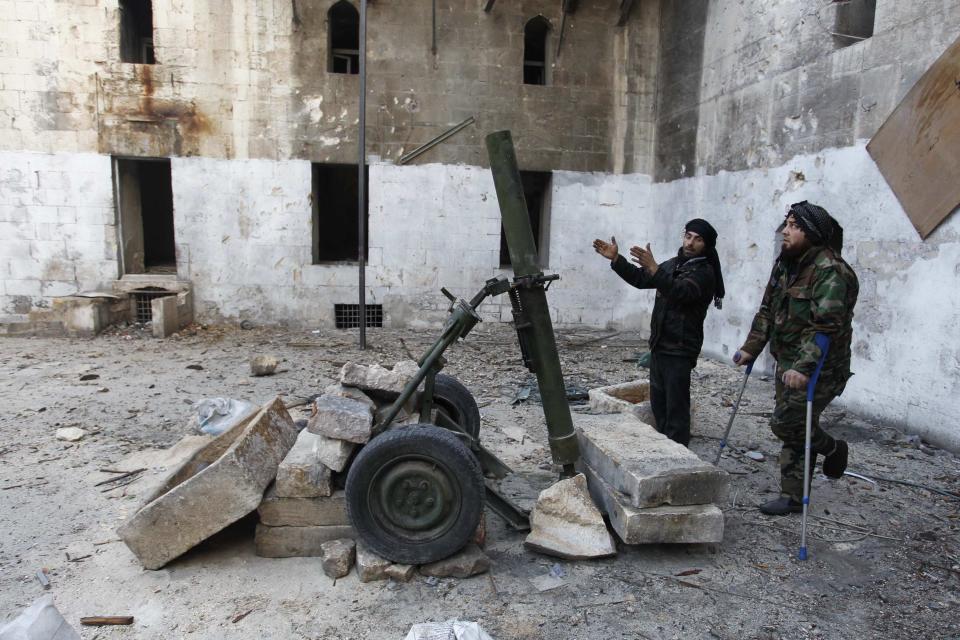 Free Syrian Army fighters prepare a rocket launcher before firing toward forces loyal to Syria's President Bashar al-Assad in Old Aleppo