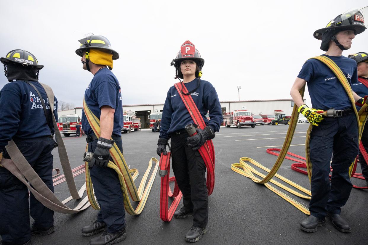 Faith Kalb, who plans to be a volunteer firefighter, holds a firehose during a training session at the Division of State Fire Marshal's Ohio Fire Academy.