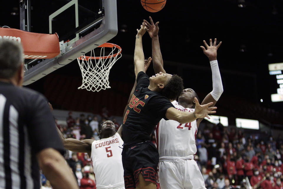 Southern California guard Boogie Ellis, center, shoots between Washington State guards TJ Bamba (5) and Noah Williams, right, during the first half of an NCAA college basketball game, Saturday, Dec. 4, 2021, in Pullman, Wash. (AP Photo/Young Kwak)