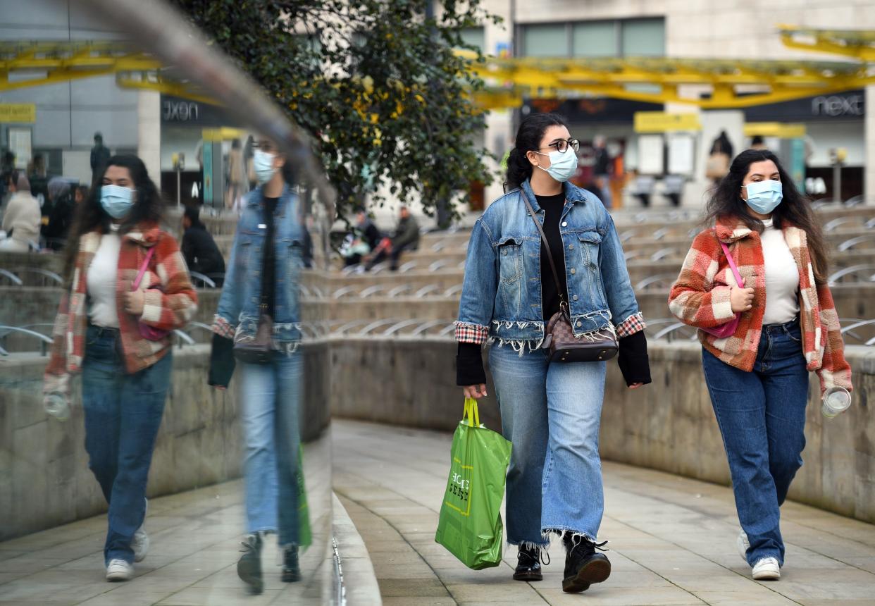 People wear PPE masks and face coverings as they walk through the city centre in Manchester, north west England on October 8, 2020. - Pubs and restaurants in coronavirus hotspots look set to face fresh restrictions after Downing Street said new data suggests there is "significant" transmission taking place in hospitality settings. A "range of measures" is being looked at, with a particular focus on northern England, where it says infection rates are rising fastest. (Photo by Oli SCARFF / AFP) (Photo by OLI SCARFF/AFP via Getty Images)