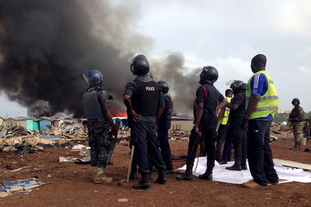 Security forces watch as residents burn dwellings in an impoverished neighborhood in Accra, Ghana, June 20, 2015. REUTERS/Staff