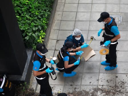 Forensic police investigators work following a small explosion at a site in Bangkok, Thailand