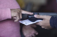 A voter registers on a finger print scanner at a polling station during general elections in Tegucigalpa, Honduras, Sunday, Nov. 28, 2021. (AP Photo/Moises Castillo)
