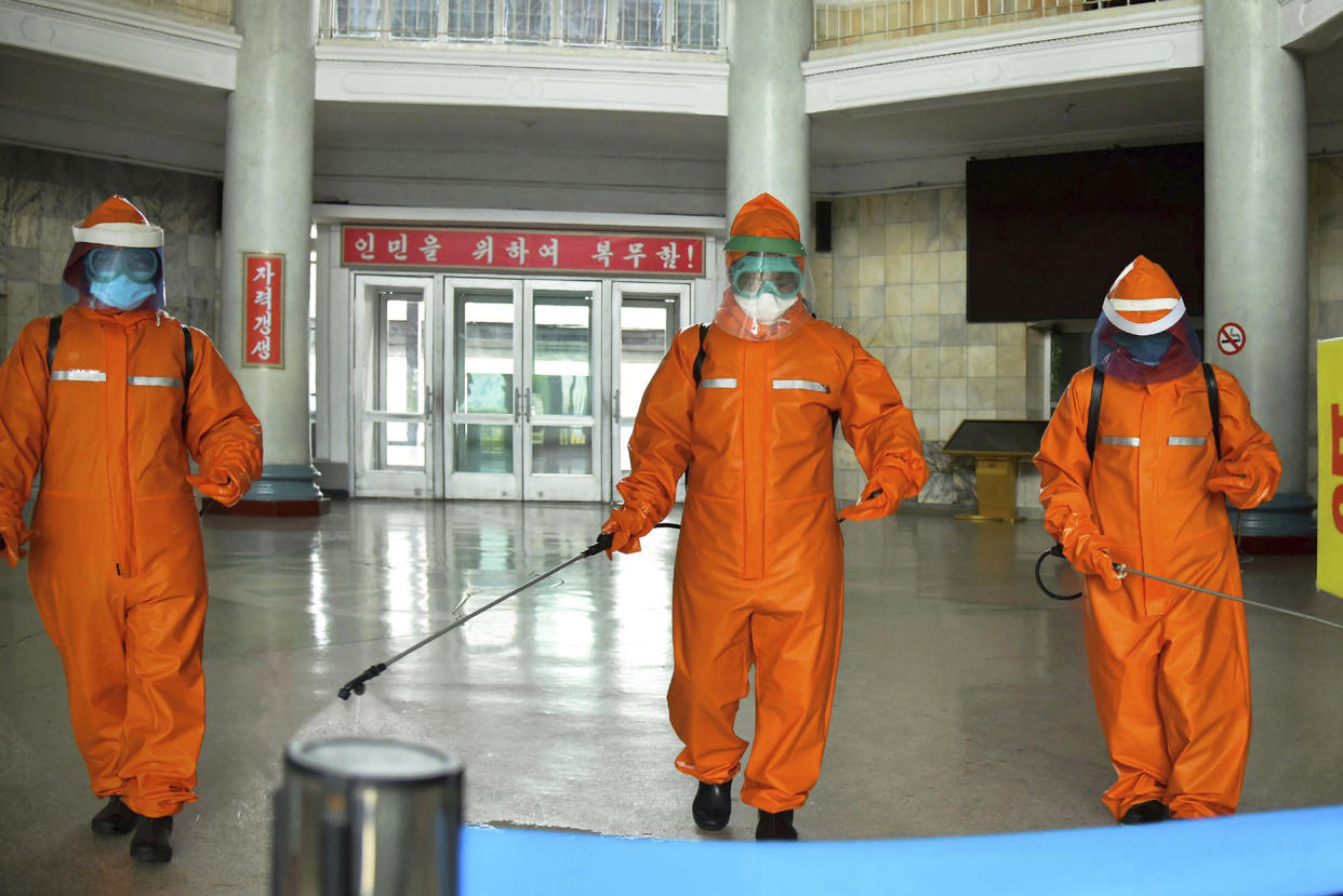 Government staff disinfect the floor of Pyongyang station on Tuesday to try to curb the spread of Covid in North Korea's capital. (KCNA  / via AP)