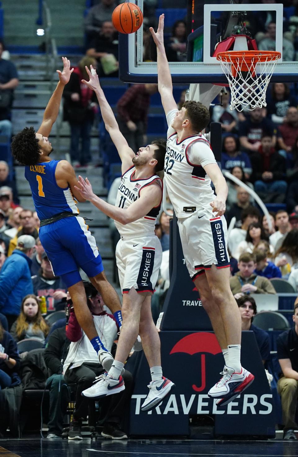 UConn center Donovan Clingan (32) and forward Alex Karaban  challenge the shot of Xavier's Desmond Claude in the first half. Claude scored 11 points but shot only 5-for-17 from the field.