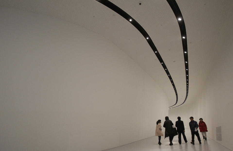 Visitors walk inside Dongdaemun Design Plaza in Seoul, South Korea, Friday, March 21, 2014. The $450 million building funded by Seoul citizen's tax money finally opened to public on Friday after years of debates about transforming a historic area with an ultra-modern architecture. (AP Photo/Ahn Young-joon)