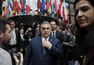 Hungarian Prime Minister Viktor Orban, center, walks out into the main press room to brief journalists during an EU summit at the European Council building in Brussels, Friday, Feb. 21, 2020. In a second day of meetings EU leaders will continue to discuss the bloc's budget to work out Europe's spending plans for the next seven years. (AP Photo/Virginia Mayo)