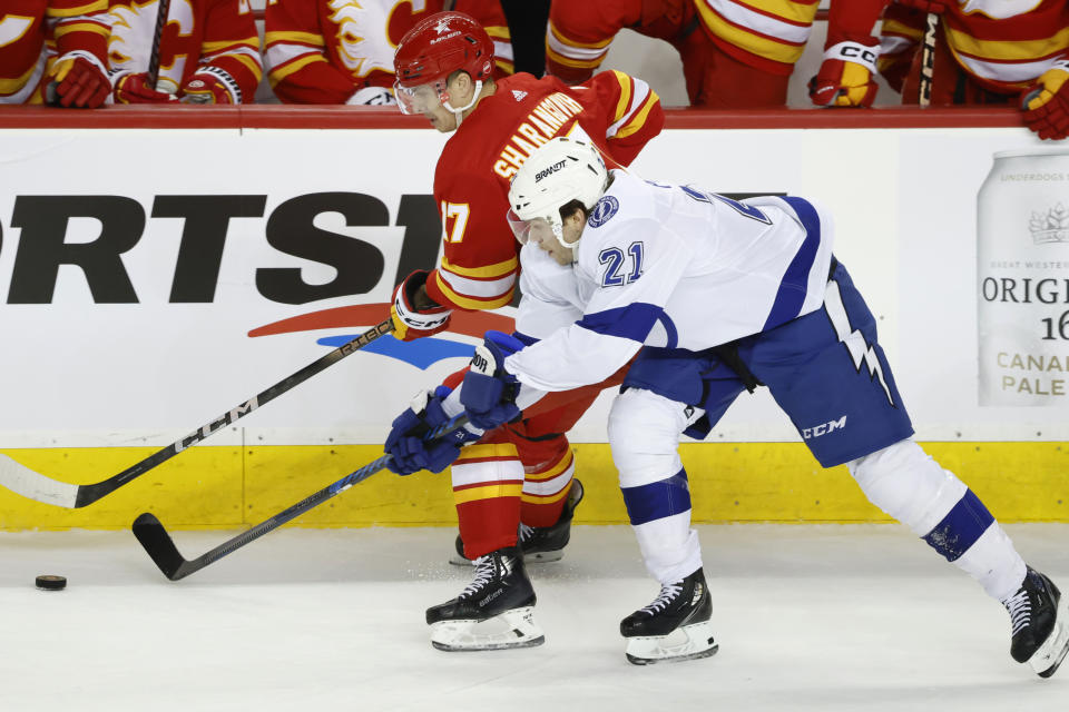 Calgary Flames center Yegor Sharangovich (17) and Tampa Bay Lightning center Brayden Point (21) vie for the puck during the first period of an NHL hockey game Saturday, Dec. 16, 2023, in Calgary, Alberta. (Larry MacDougal/The Canadian Press via AP)