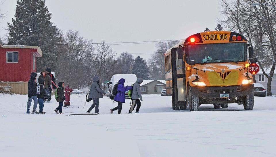 Children in winter coats line up to get into a school bus Thursday, March 21, 2024 in Bismarck, N.D (AP)