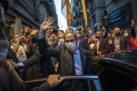 Catalonia's outgoing regional president, Quim Torra, waves to the crowd as he leaves the Generalitat Palace in Barcelona, Spain on Monday, Sept. 28, 2020. Spain's Supreme Court has barred Catalonia's regional president from his office for refusing to remove a banner calling for the release of separatist leaders from prison that was displayed on a public building ahead of the 2019 general election (AP Photo/Emilio Morenatti)