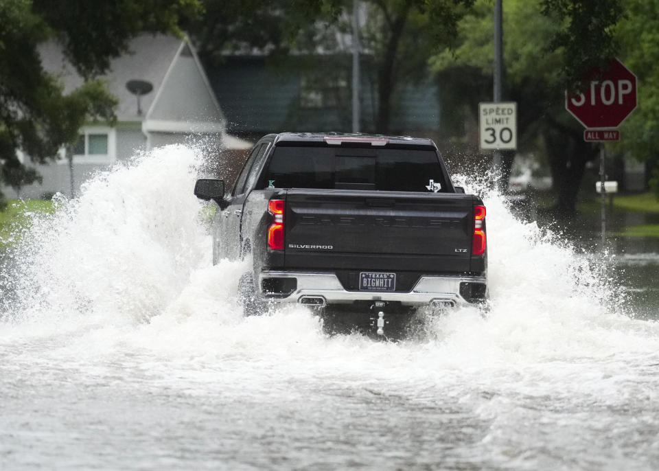 A truck drives through flood water in North Woodland Hills after severe flooding, Thursday, May 2, 2024, in the Houston neighborhood of Kingwood, Texas. (Jason Fochtman/Houston Chronicle via AP)