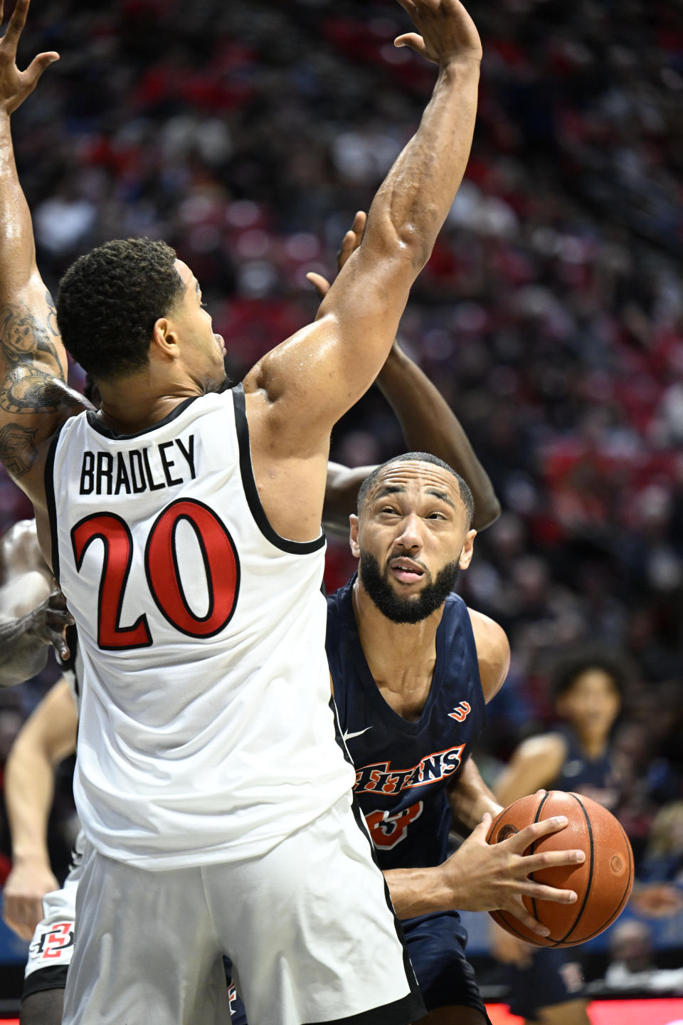 Cal State Fullerton forward Vincent Lee (13) tries to shoot past San Diego State guard Matt Bradley (20) during the first half of an NCAA college basketball game Monday, Nov. 7, 2022, in San Diego. (AP Photo/Denis Poroy)