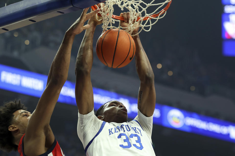 Kentucky's Ugonna Onyenso (33) dunks while defended by Mississippi's Jaemyn Brakefield, left, during the first half of an NCAA college basketball game Tuesday, Feb. 13, 2024, in Lexington, Ky. (AP Photo/James Crisp)