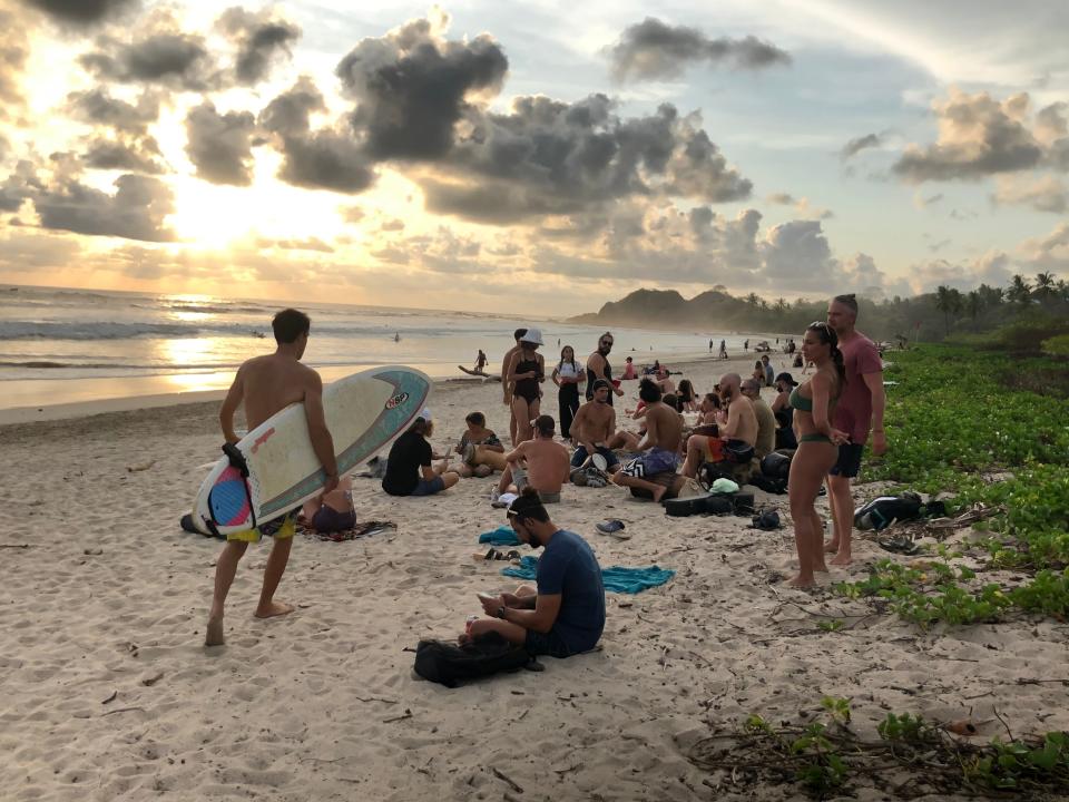 Visitors gather to watch the sunset April 19, 2021, in Playa Guiones, a surfing destination located near the town of Nosara, Costa Rica. U.S. travelers need to carry proof of vaccination to enter the country.