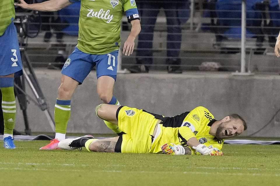 Seattle Sounders goalkeeper Stefan Frei (24) grimaces after colliding with a San Jose Earthquakes player during the second half of an MLS soccer match Wednesday, May 12, 2021, in San Jose, Calif. The Sounders won 1-0. (AP Photo/Tony Avelar)