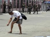 A man picks up bullet casings after Muslim rebels members of the Moro National Liberation Front (MNLF) clashed with government soldiers in Zamboanga city, southern Philippines September 9, 2013. Muslim rebels took 30 civilian hostages in the southern Philippines on Monday and held security forces in a standoff as part of a drive to derail peace talks, officials said. Police commandos cordoned off parts of Zamboanga City on the island of Mindanao after a rogue faction of the MNLF took hostages and tried to march to the city hall to raise their flag, an army commander said. REUTERS/Stringer (PHILIPPINES - Tags: POLITICS MILITARY CIVIL UNREST)