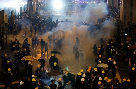 FILE PHOTO: Anti-extradition demonstrators run from tear gas after a march of to call for democratic reforms, in Hong Kong