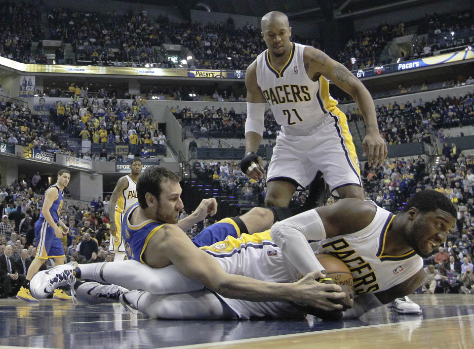 Indiana Pacers' Roy Hibbert (55) and Golden State Warriors' Andrew Bogut (12) battle for a loose ball as David West (21) watches during the first half of an NBA basketball game Tuesday, March 4, 2014, in Indianapolis. (AP Photo/Darron Cummings)