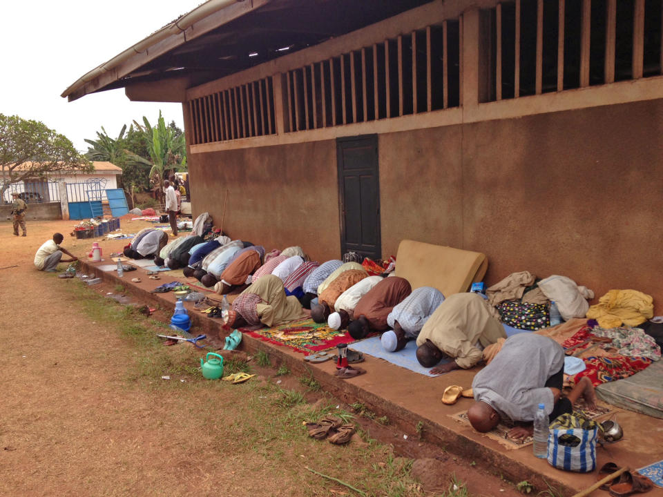 In this photo taken on Sunday, Feb. 23, 2014, Muslims pray as they hide at a Catholic church in Carnot a town 200 kilometers (125 miles) from the Cameroonian border, in, Central African Republic. The Christian militiamen knew hundreds of Muslims were hiding at the Catholic church and came with their ultimatum: Evict the families to face certain death or else the entire place would be burned to the ground. (AP Photo/Krista Larson)