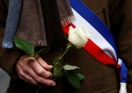 An official holds a white rose as he attends a gathering, organised by the CRIF, in memory of Mireille Knoll, in Paris, France, March 28, 2018. REUTERS/Gonzalo Fuentes