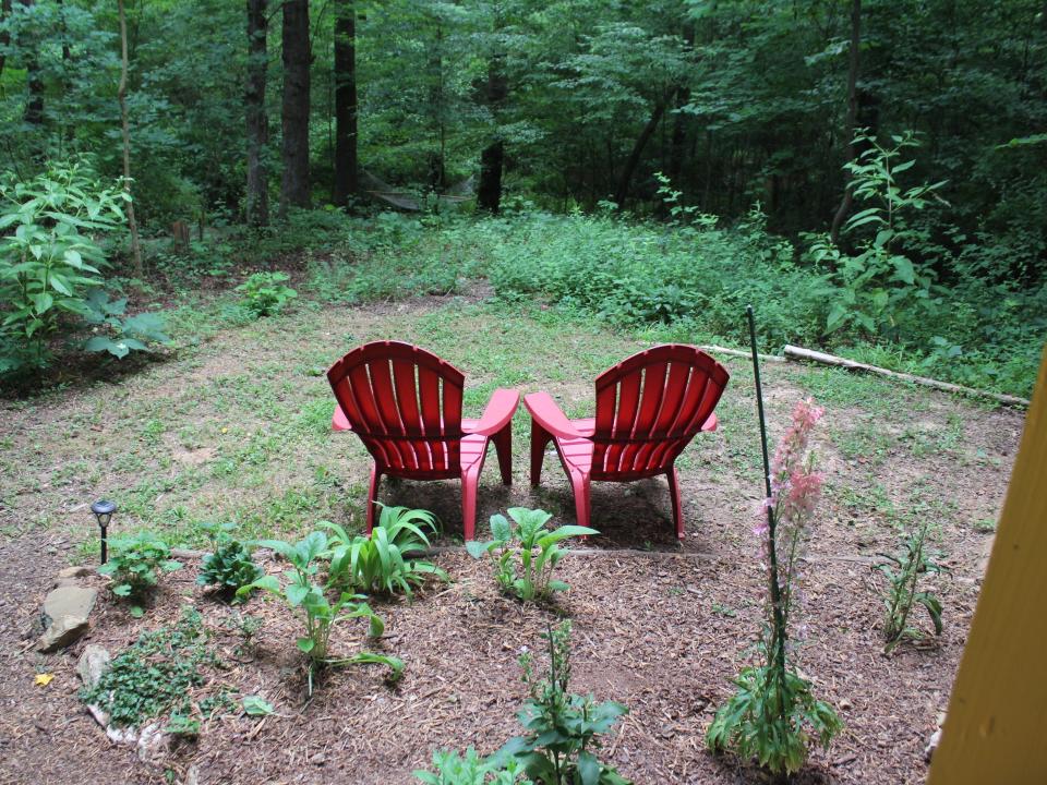 two red chairs outside looking over the woods