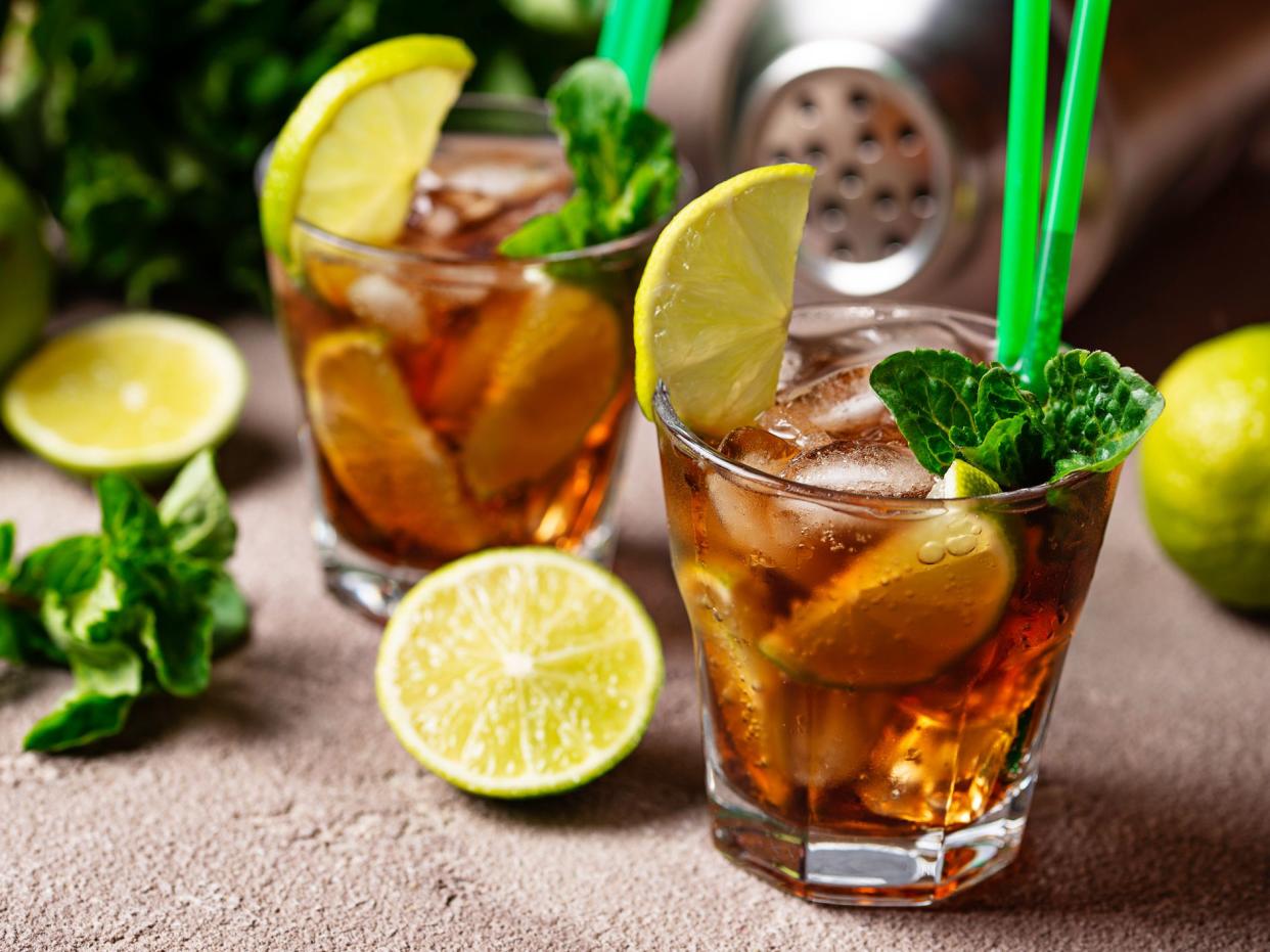Cuba libre cocktail with mint, lime and ice
