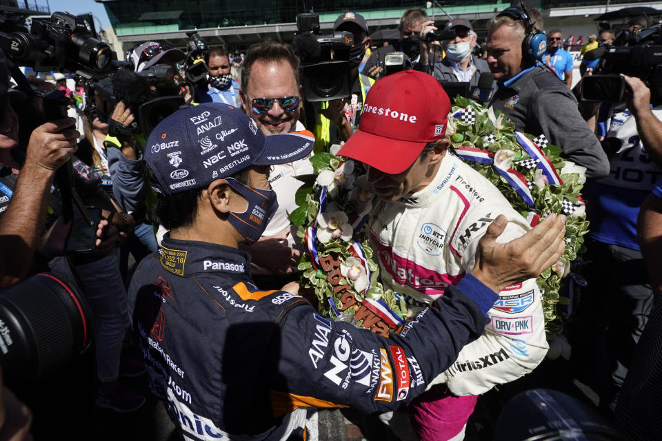 Helio Castroneves, of Brazil, is congratulated by Takuma Sato, of Japan, after Castroneves, won the Indianapolis 500 auto race at Indianapolis Motor Speedway, Sunday, May 30, 2021, in Indianapolis. (AP Photo/Darron Cummings)