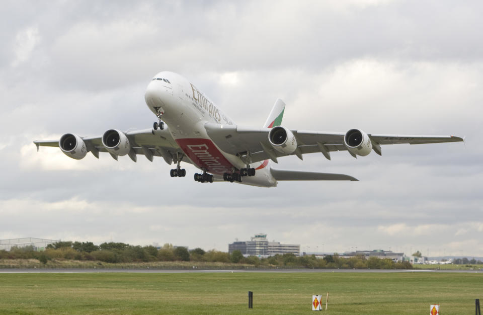 A stock photo of an Emirates plane taking off from a runway.