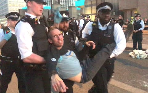 Screengrab from a video of Olympic gold medalist Etienne Stott being arrested by police at the Extinction Rebellion demonstration on Waterloo Bridge in London - Credit: PA&nbsp;