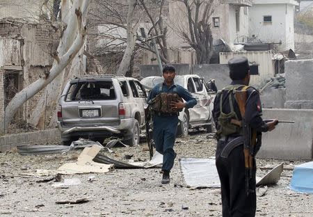 An Afghan policeman runs during the gunfire in front of the Indian consulate in Jalalabad, Afghanistan March 2, 2016. REUTERS/Parwiz