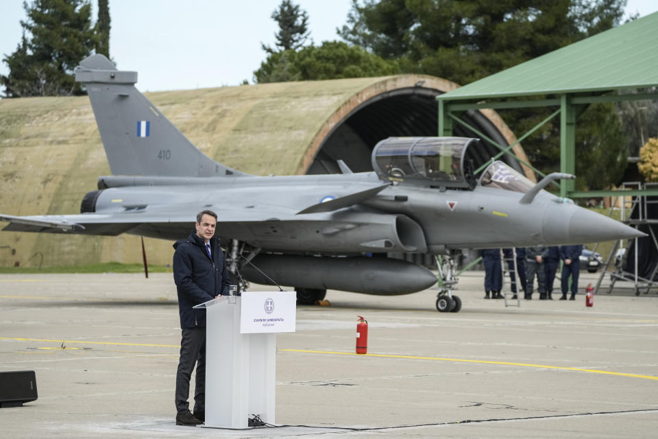 Greek Prime Minister Kyriakos Mitsotakis speak in front to a Rafale jet during a hand over ceremony in Tanagra military air base, about 82 kilometres (51miles) north of Athens, Greece, on Wednesday, Jan. 19, 2022. Six advanced-tech Rafale jets bought from the French air force were handed over Wednesday to the Greek armed forces ‒ the first major delivery to result from multi-billion euro defense deals sealed with Paris last year. (AP Photo/Thanassis Stavrakis)