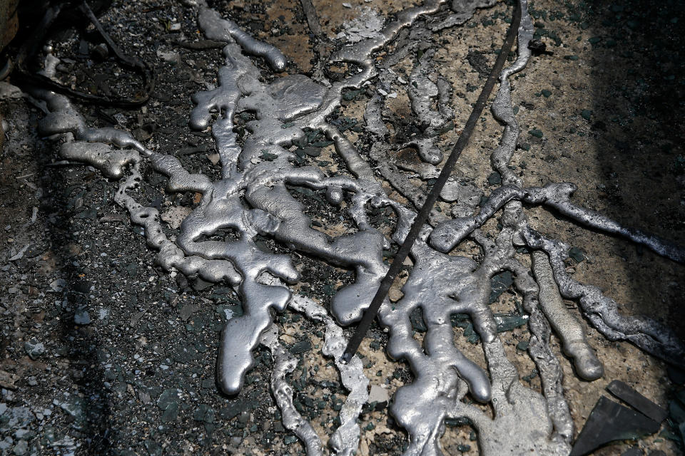 <p>Melted aluminium from cars is seen on the ground following a wildfire at the village of Mati, near Athens, Greece, July 24, 2018. (Photo: Costas Baltas/Reuters) </p>