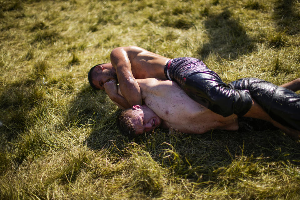 Wrestlers compete during the 661st annual Historic Kirkpinar Oil Wrestling championship, in Edirne, northwestern Turkey, Saturday, July 2, 2022. The festival is part of UNESCO's List of Intangible Cultural Heritages. (AP Photo/Francisco Seco)