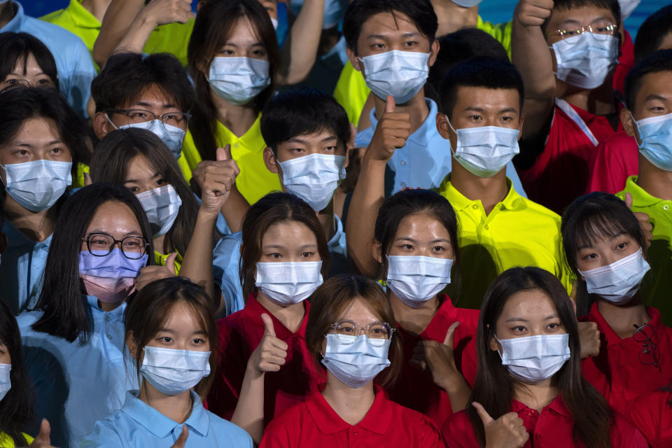 Participants wearing face masks pose for a group photo after a launch ceremony to reveal the motto for the 2022 Beijing Winter Olympics and Paralympics in Beijing, Friday, Sept. 17, 2021. Organizers on Friday announced "Together for a Shared Future" as the motto of the next Olympics, which is scheduled to begin on Feb. 4 of next year. (AP Photo/Mark Schiefelbein)