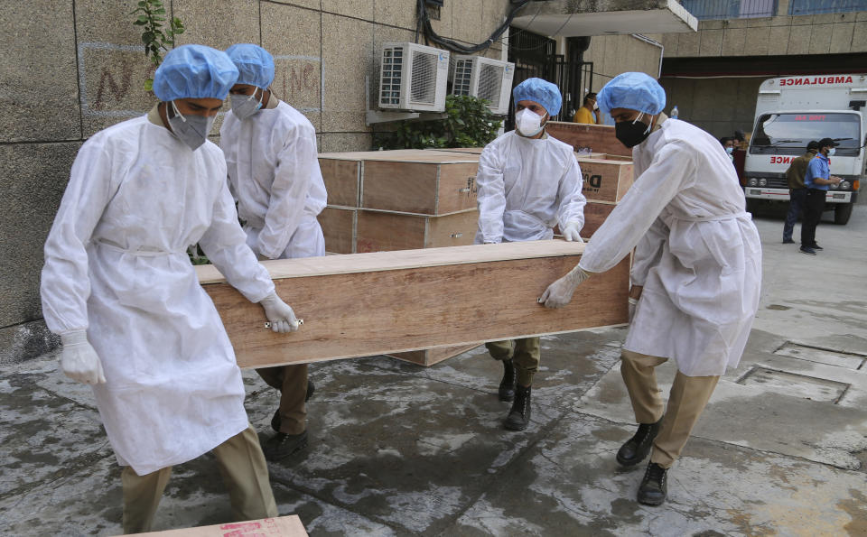 Jammu and Kashmir State Disaster Response Force soldiers carry empty coffins for transporting bodies of people who died of COVID-19 outside government medical hospital in Jammu, India, Wednesday, May 19, 2021. (AP Photo/Channi Anand)