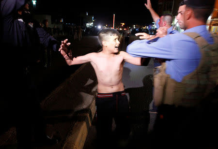 Iraqi security forces detain a boy after removing a suicide vest from him in Kirkuk, Iraq, August 21, 2016. REUTERS/Ako Rasheed