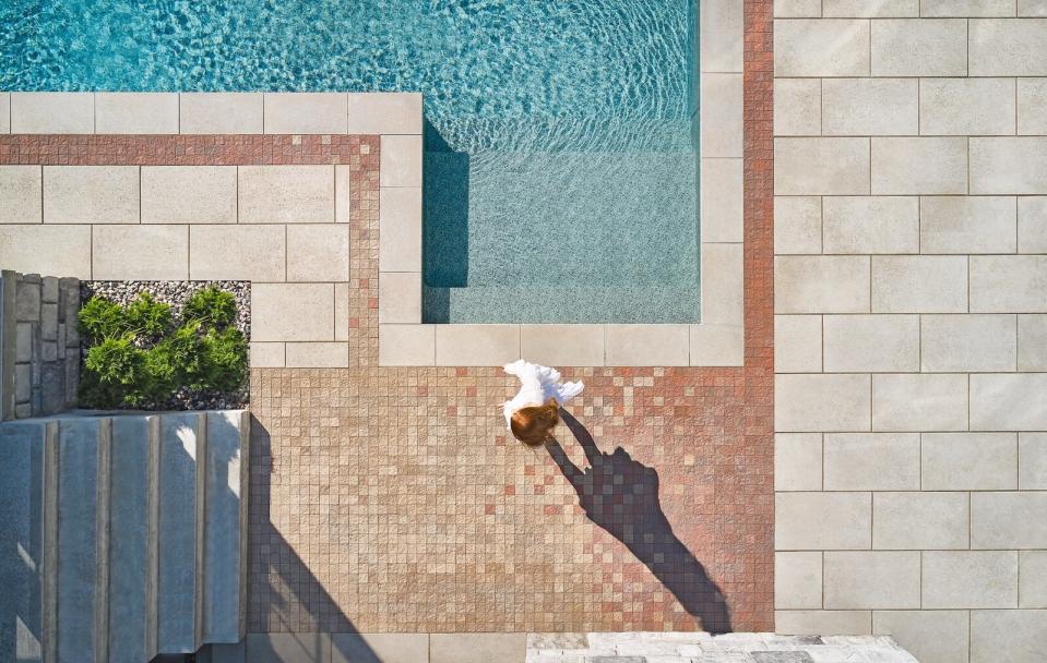 A subtle ombre effect has been created around the pool using the Techo-Bloc Squadra paver in Chestnut Brown with Merlot scattered throughout. The edge of the pool is graphically defined using the Blu Grande slab in Beige Cream to create a striking and sophisticated composition.