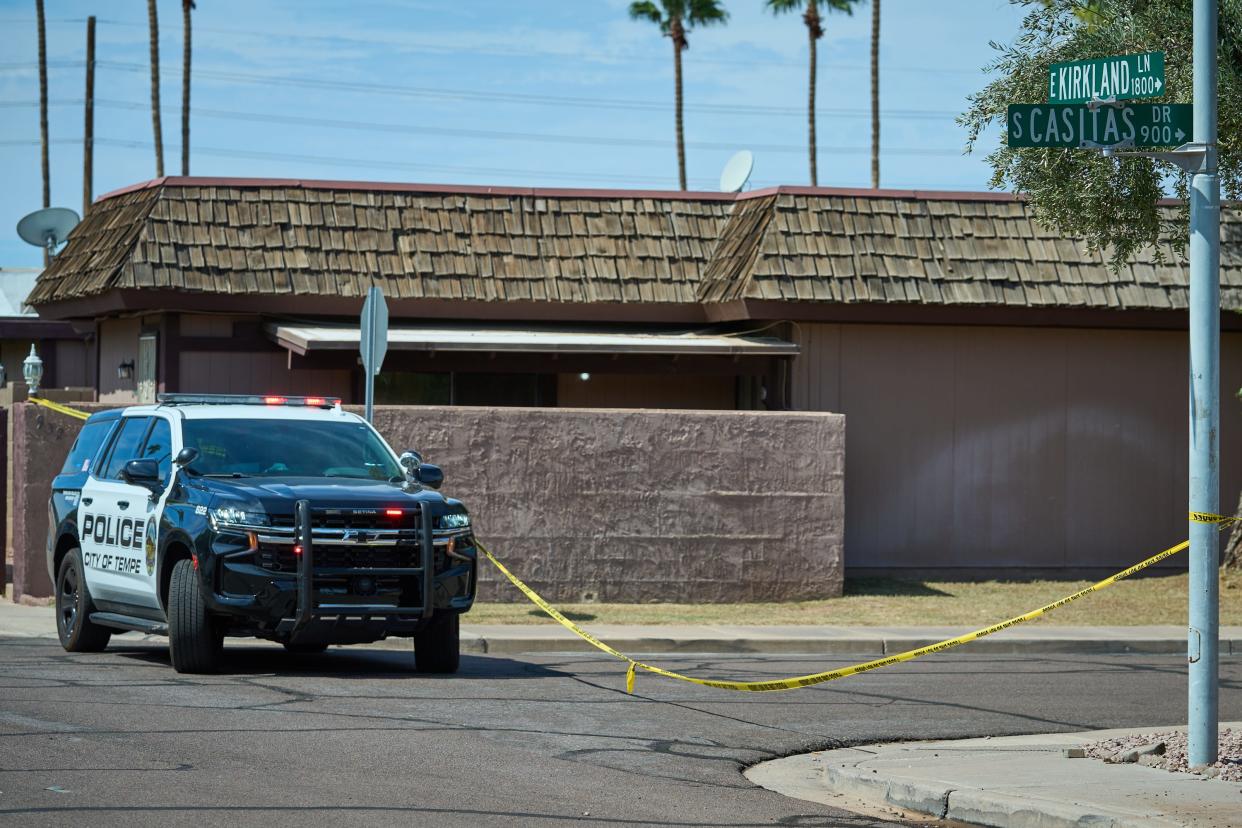 A Tempe Police cruiser and tape blocks access to the street that leads to the scene of a house fire that left one woman and a dog on East Kirkland Lane and South Casitas Drive on Sept. 28, 2022.