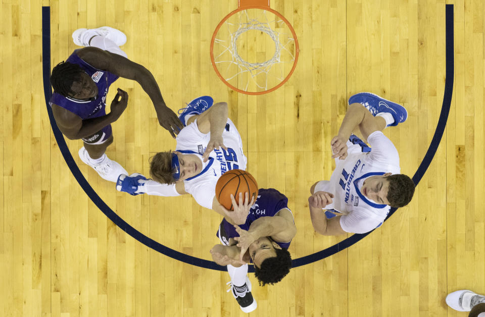 Creighton's Baylor Scheierman, second from left, snags a rebound over Holy Cross' Caleb Kenney, second from right, as Holy Cross' Gerrale Gates, left, and Creighton's Ryan Kalkbrenner, right, stand by during the first half of an NCAA college basketball game on Monday, Nov. 14, 2022, in Omaha, Neb. (AP Photo/Rebecca S. Gratz)
