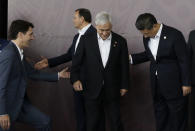 Canada Prime Minister Justin Trudeau, left, and Chinese President Xi Jinping, right, help Chilean President Sebastian Pinera, center, during the family photo at the APEC Economic Leaders Meeting at Port Moresby, Papua New Guinea on Sunday, Nov. 18, 2018. (AP Photo/Aaron Favila)