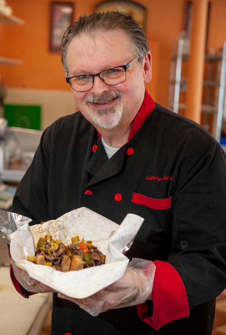 Alex Palterman, owner and executive chef at Culinary Delights in Natick with a Chicago style Italian beef sandwich: roll dipped in au jus, 1/3 pound of homemade Italian seasoned Angus roast beef, sauteed sweet peppers, and hot giardiniera, Aug. 4, 2023.