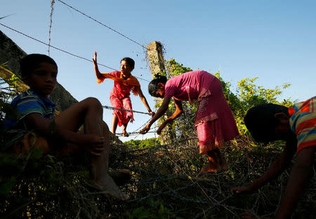 Rohingya children cross the Bangladesh-Myanmar border fence as they try to enter Bangladesh in Bandarban, an area under Cox's Bazar authority, Bangladesh. REUTERS/Mohammad Ponir Hossain