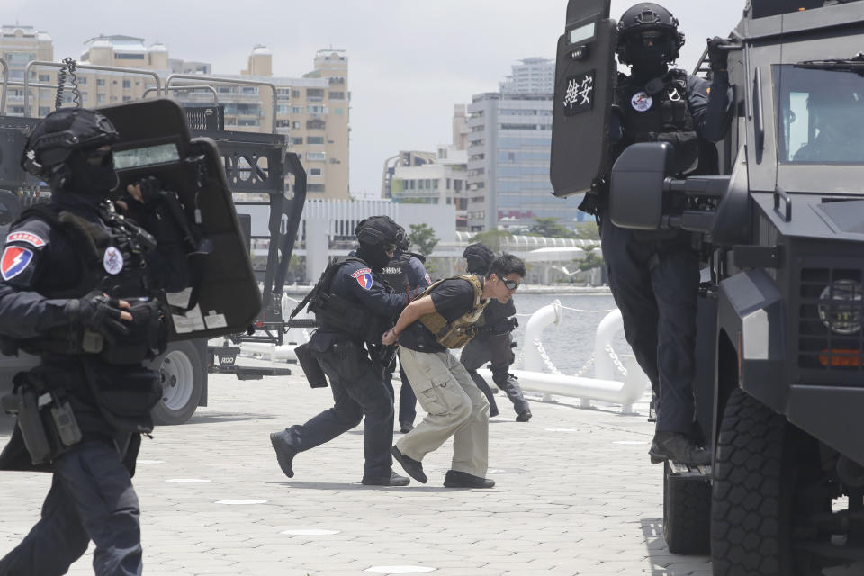 Crew members of the Taiwan Coast Guard perform during an offshore anti-terrorism drill outside the Kaohsiung harbor in Kaohsiung, southwestern Taiwan, Saturday, June 10, 2023. During Saturday's drills, Taiwanese security officers demonstrated how they would defend against terrorist acts at sea. Some climbed from small boats onto a vessel controlled by “terrorists” and brought them under control. Others rappelled down from a flying helicopter. The stimulation ended with a dramatic scene in which some officers hung in the air as they were sent back to the helicopter.(AP Photo/Chiang Ying-ying)