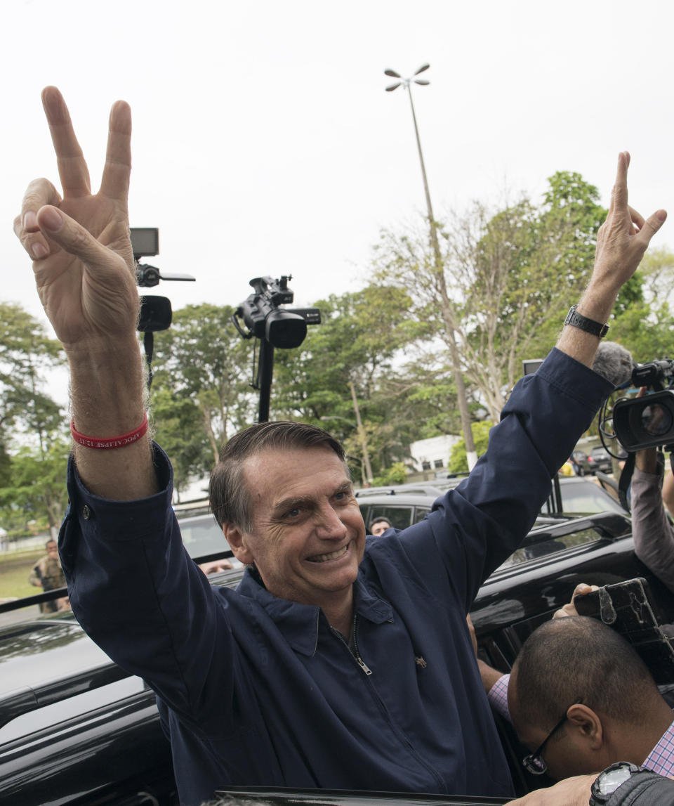 Presidential frontrunner Jair Bolsonaro, of the Social Liberal Party, flashes victory hand signs to supporters after voting at a polling station in Rio de Janeiro, Brazil, Sunday, Oct. 7, 2018. Brazilians choose among 13 candidates for president Sunday in one of the most unpredictable and divisive elections in decades. If no one gets a majority in the first round, the top two candidates will compete in a runoff. (AP Photo/Leo Correa)