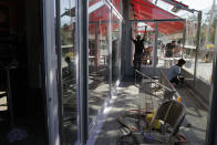 People prepare the terrace of their restaurant in Boulogne-Billancourt, outside Paris, Thursday, May 28, 2020. France is reopening its restaurants, bars and cafes starting next week as the country eases most restrictions amid the coronavirus crisis. Edouard Philippe defended the gradual lifting of lockdown up to now, saying the strategy was meant to avoid provoking a second wave. (AP Photo/Christophe Ena)