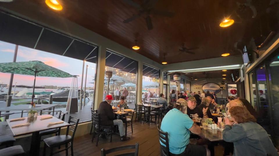Diners enjoy a view of a sunset-pink sky over the marina at Lake Eustis Waterfront Grille.