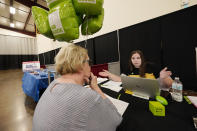 Jamie Snyder, right, of H&R Block, explains the training process to applicant Diane Moore, during the Lee County Area Job Fair in Tupelo, Miss., Tuesday, Oct. 12, 2021. Employers representing a variety of manufacturing, production, service industry, medical and clerical companies attended the day long affair with an eye towards recruitment, hiring, training and retention. (AP Photo/Rogelio V. Solis)