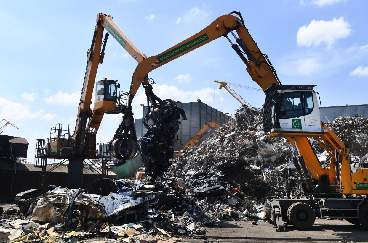This picture taken on July 2, 2019 in Guyot Environnement recycling company shows cranes lifting an old scrap car next to a pile of mettalic waste, in Brest, western France. - Guyot Environnement announced on July 2, 2019 the buy-out of the Spanish company Hirumet. (Photo by Fred TANNEAU / AFP)        (Photo credit should read FRED TANNEAU/AFP/Getty Images)