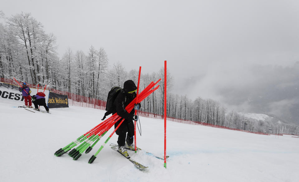 Poles marking the course are being taken out as a training session for a women's downhill race of the alpine ski World Cup, in Rosa Khutor, Russia, was cancelled due to adverse weather conditions Friday, March 1, 2019. (AP Photo/Gabriele Facciotti)