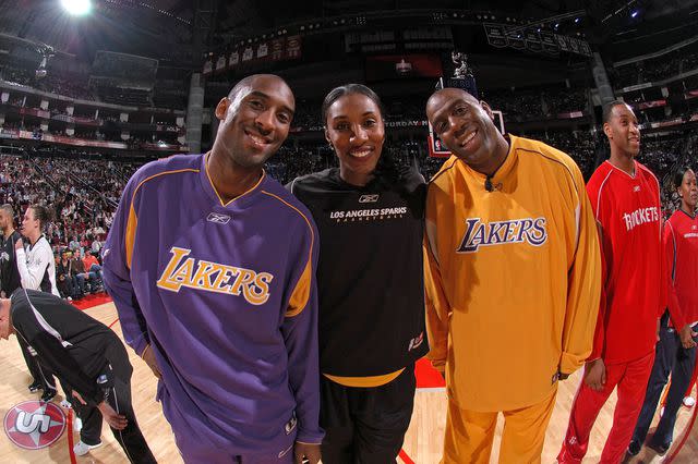 <p>Andrew D. Bernstein/NBAE via Getty</p> Kobe Bryant #8 of the Los Angeles Lakers, Lisa Leslie #9 of the Los Angeles Sparks and former Los Angeles Lakers guard Earvin "Magic" Johnson pose for a photo during the Radio Schack Shooting Stars competition on All-Start Saturday Night during 2006 All-Star Weekend February 18, 2006